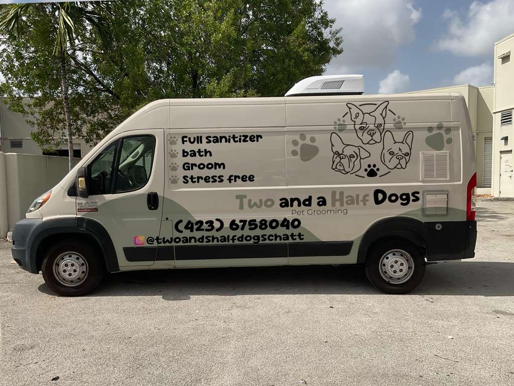 Two and a Half Dogs mobile grooming van parked outside